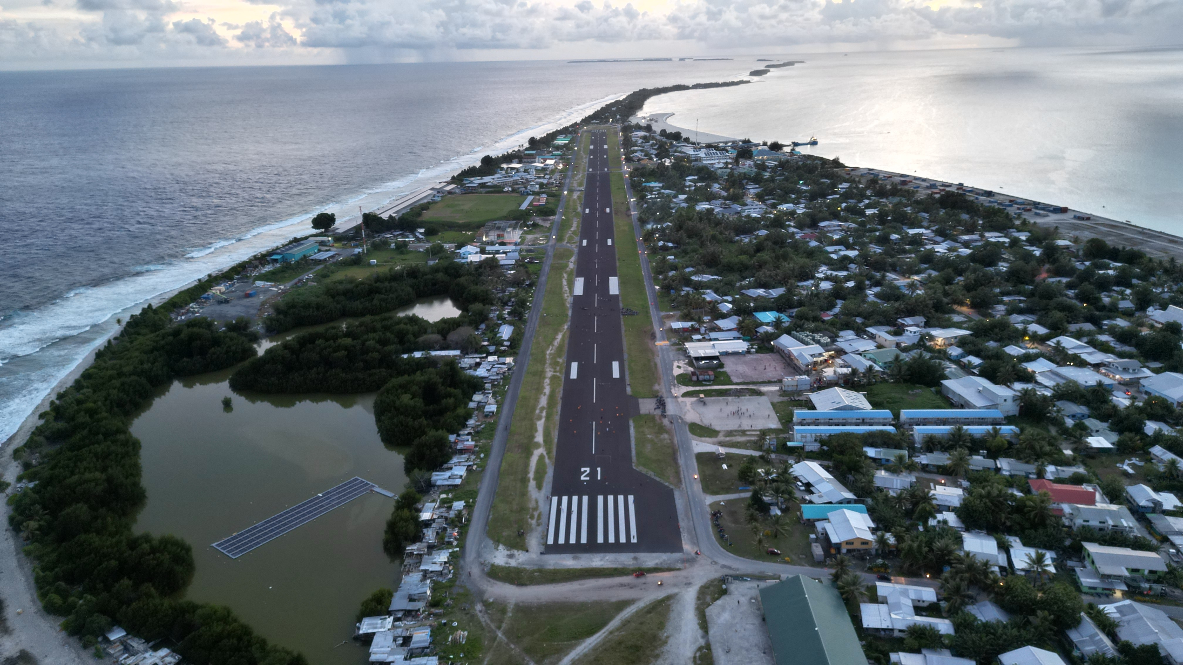 A drone shot of Tuvalu's only international runway surrounded by ocean.