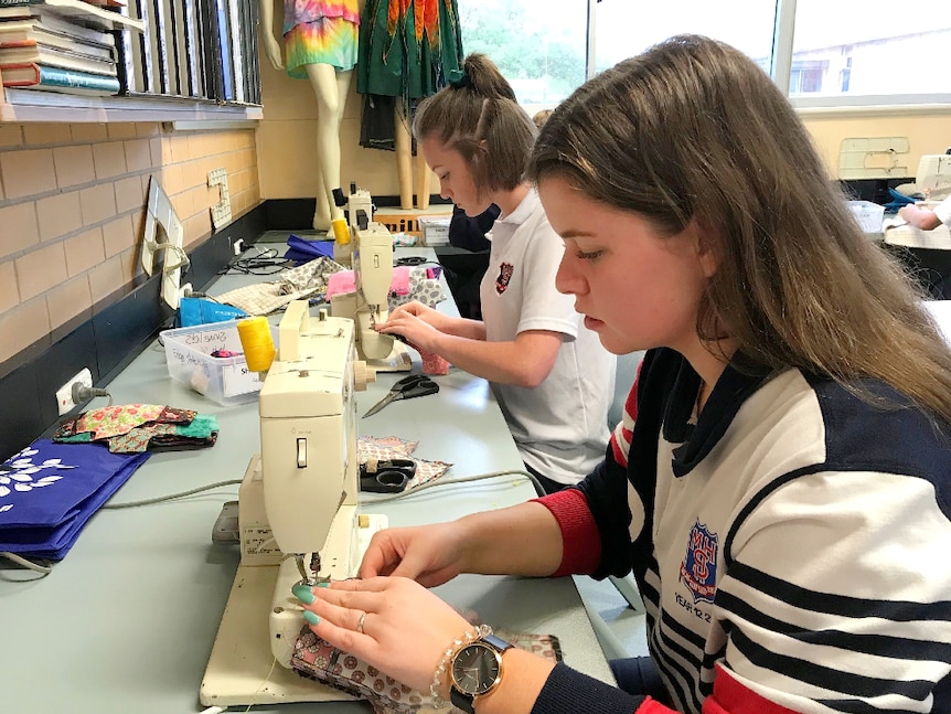 Year 12 female students at sewing machines.