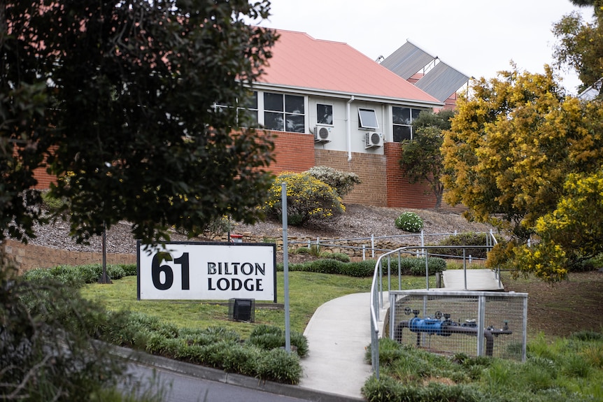 A building behind a tree with a sign reading: 61 Bilton Lodge