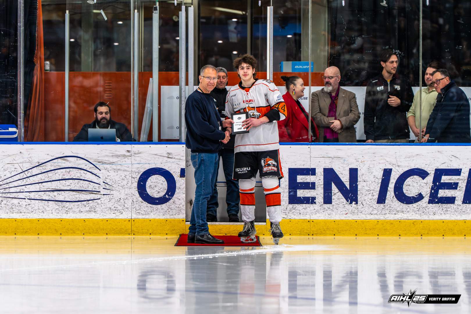 Dan Hogan on an ice rink speaking to a hockey player. 