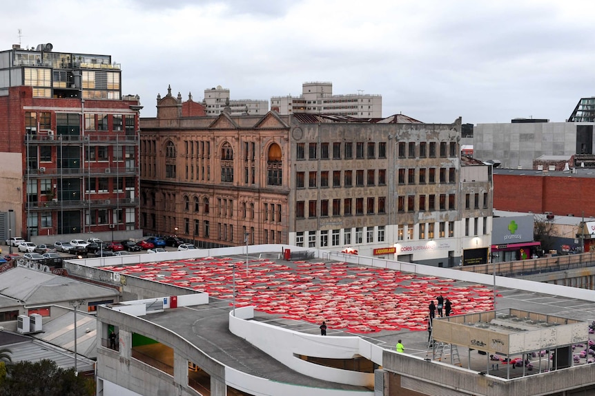 Several hundred people lie on the ground for a Spencer Tunick photoshoot.