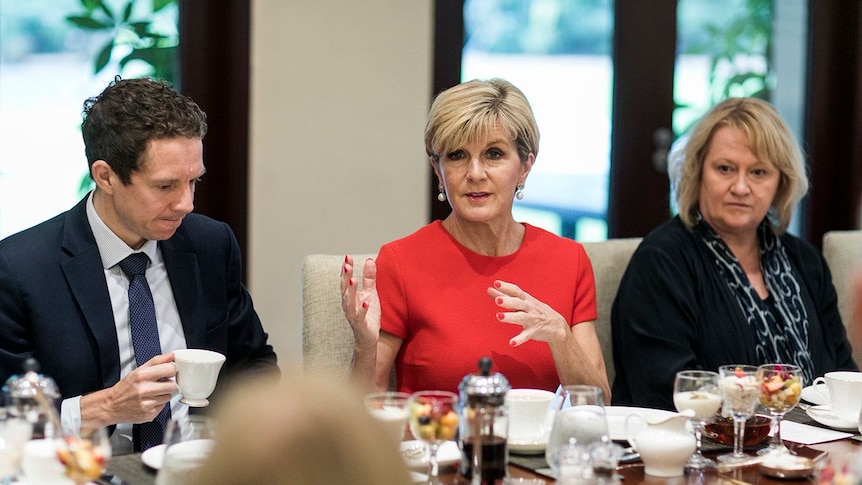 Julie Bishop speaks at a table covered in food and tea.