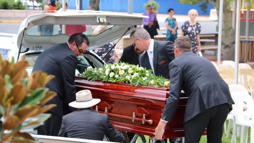 Four men help carry Lady Florence Bjelke-Petersen’s coffin outside her funeral.