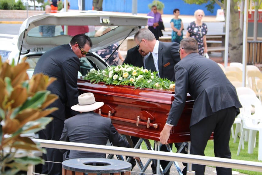 Four men help carry Lady Florence Bjelke-Petersen’s coffin outside her funeral.