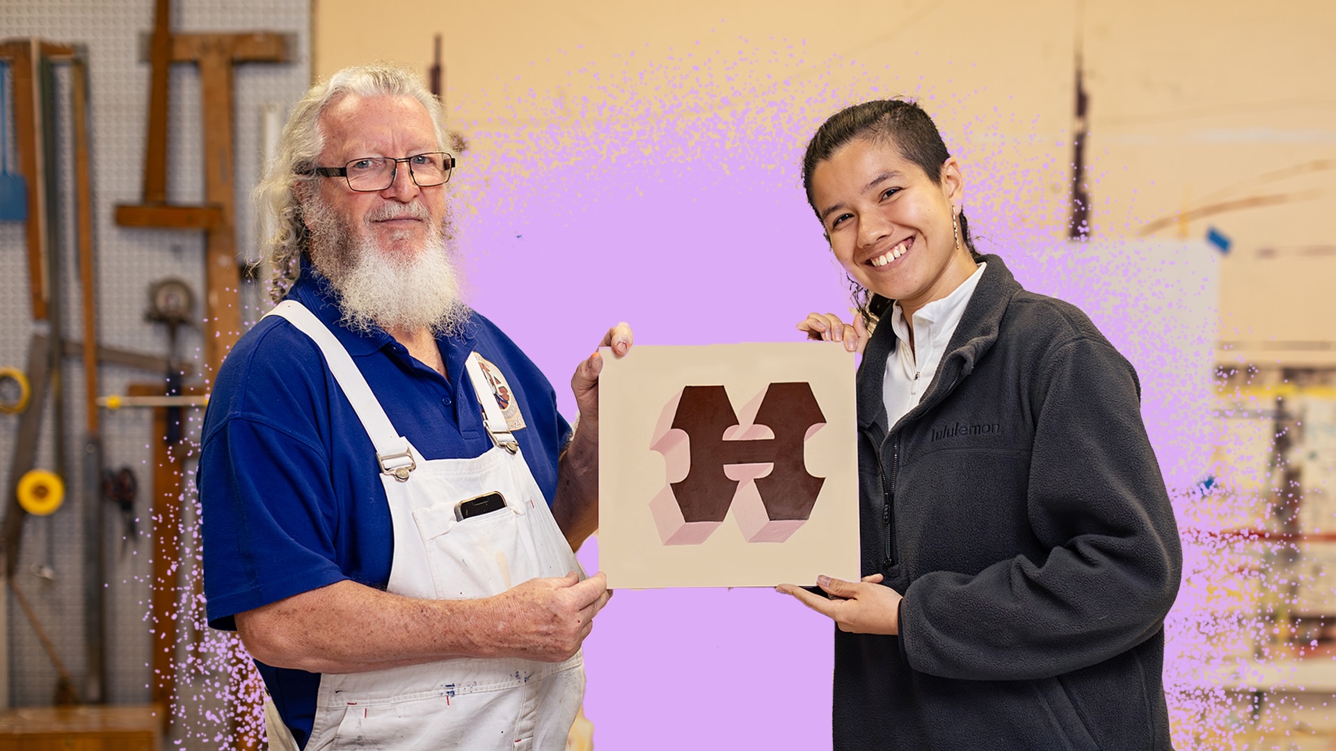 BJ smiles and looks at the camera as he holds up a sign with Halle, right. 