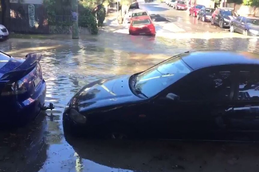 Cars on the street in water after burst water main.