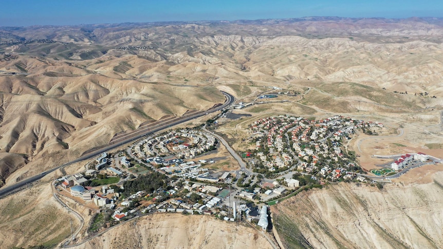 An aerial view shows a West Bank Jewish settlement surrounded by bare mountains.