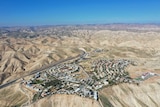 An aerial view shows a West Bank Jewish settlement surrounded by bare mountains.