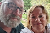 A man with a grey beard and glasses with a blonde woman in a selfie