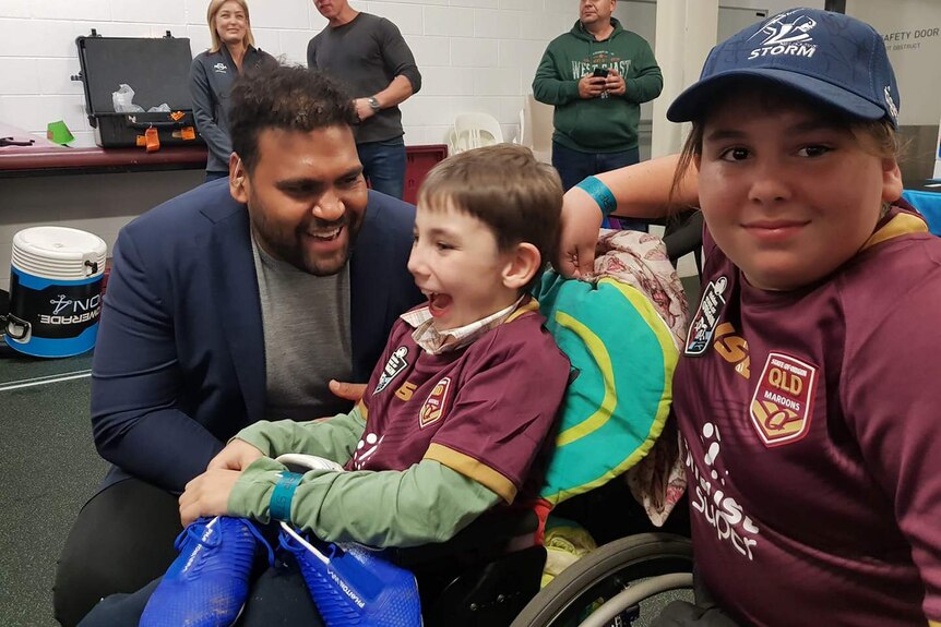 Young boy with Broncos players Sam Thaiday.