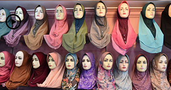 Rows of mannequin heads displaying headscarves.