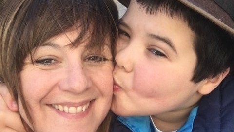 A boy kissing his mother on the cheek