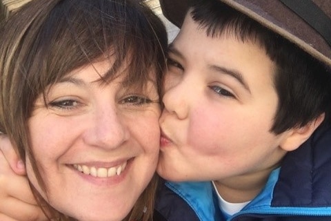 A boy kissing his mother on the cheek