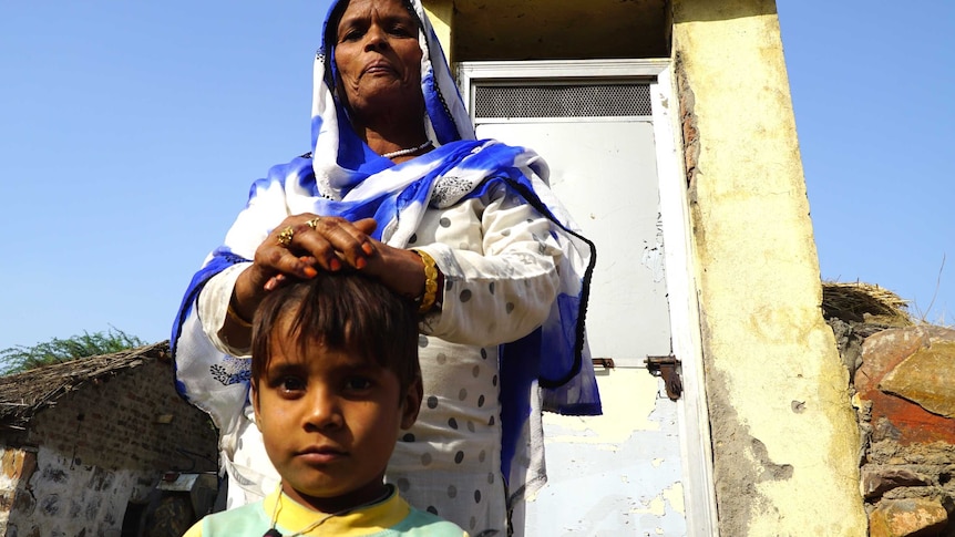 Mehram Habeeb and son in front of toilet in an Indian village where people are fined for outside defecation.