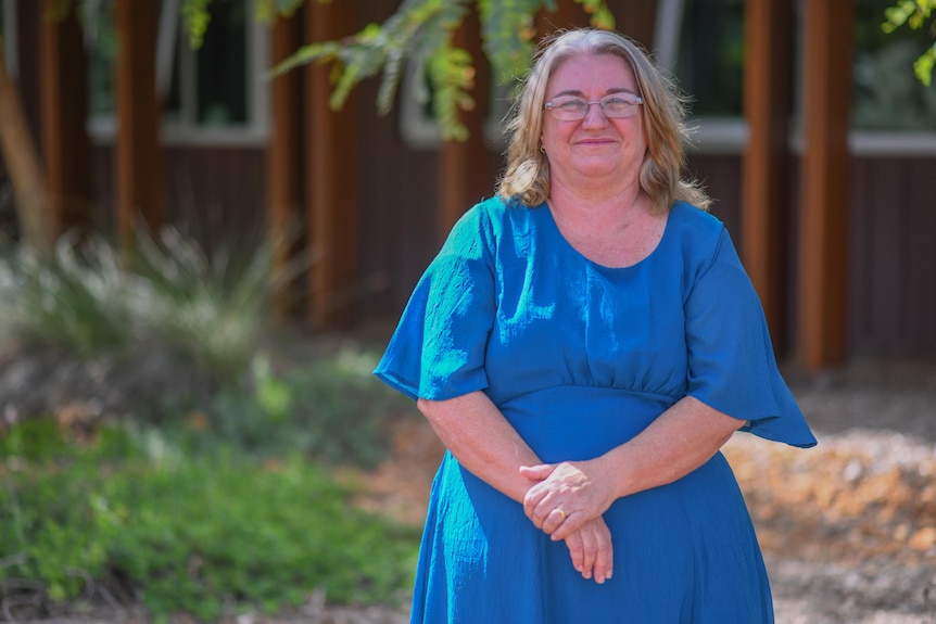 Women in blue dress stands in garden