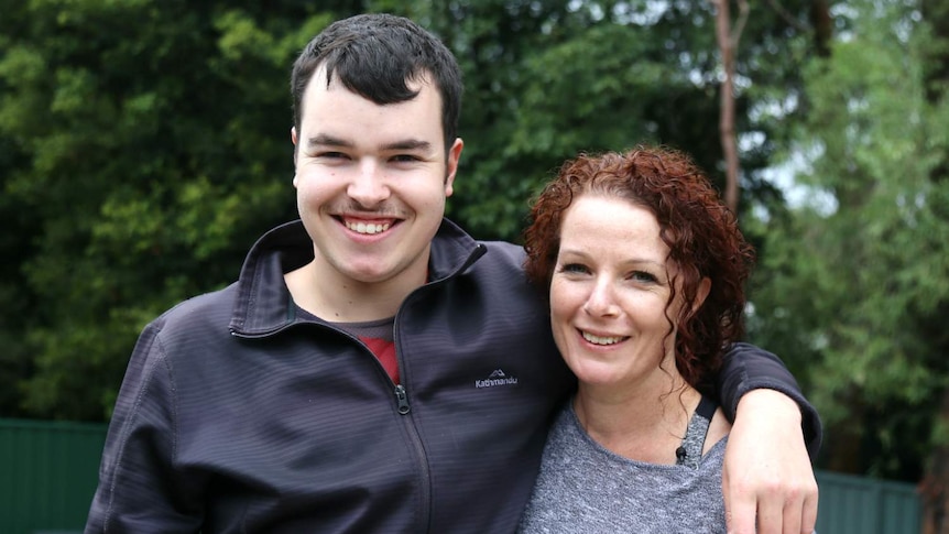 A boy and a woman look at the camera.