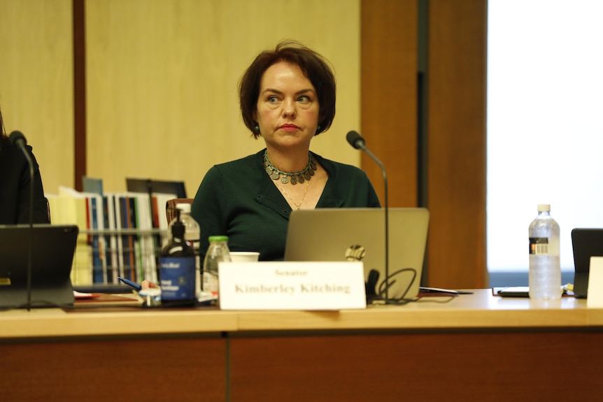 Kimberley Kitching sits at a desk in a wood panelled room