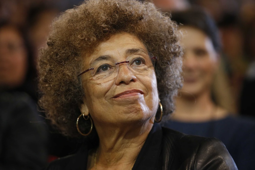 Angela Davis listens to a speech at a political meeting in France.