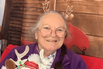 elderly woman smiling holding teddy 
