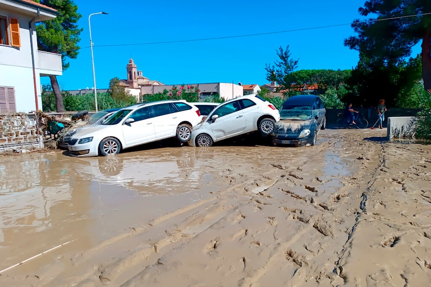 Cars stuck in mud after flooding in Italy. 