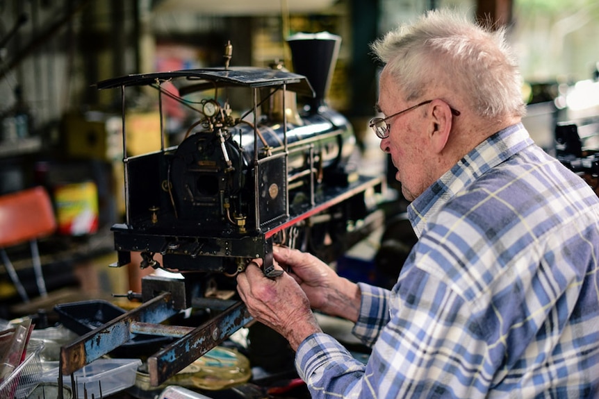 Rail enthusiast Neil MacKenzie, working on one of his miniature locomotives at his home on Brisbane