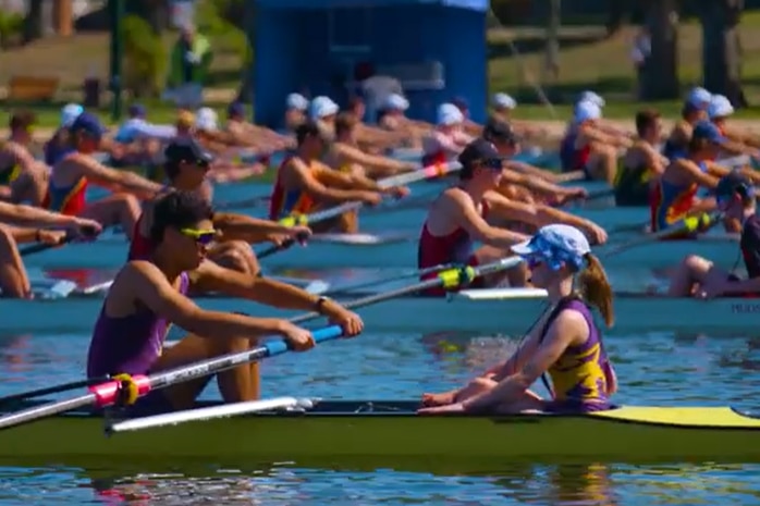 several rowing crews at the start line ahead of a rowing race