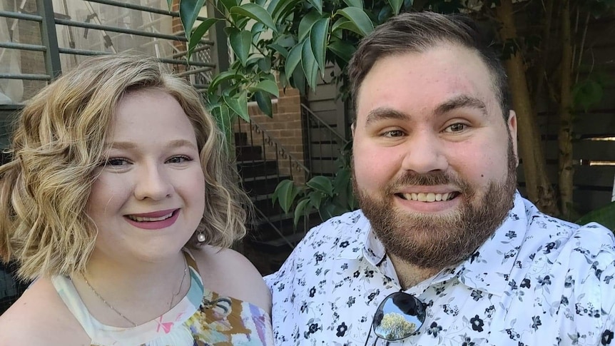 A close-up of a woman and man standing together, smiling.