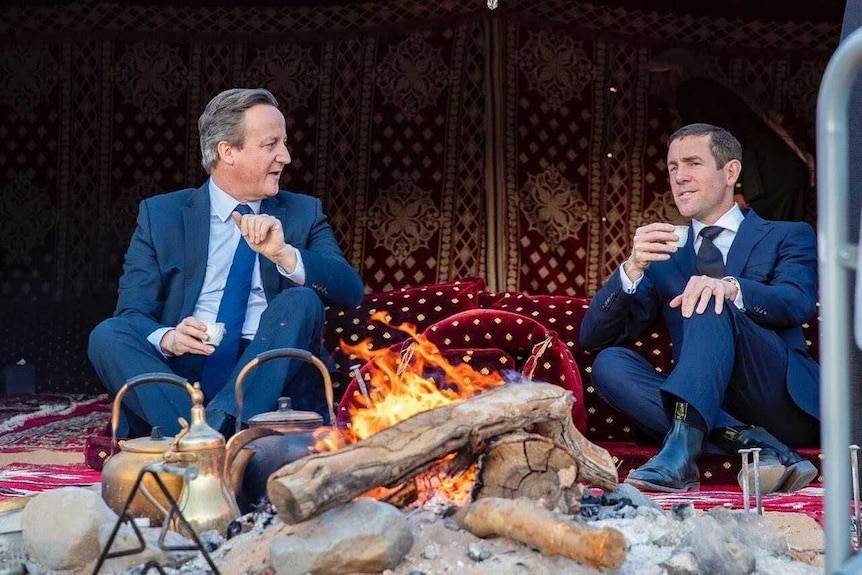 Former Prime Minister David Cameron pictured with Lex Greensill sitting on middle eastern rug