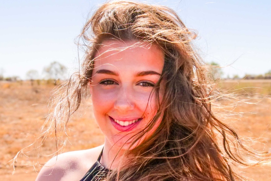 A close-up shot of teenager dancer Melanie Kilili from Longreach with her long brown hair flying in the wind.