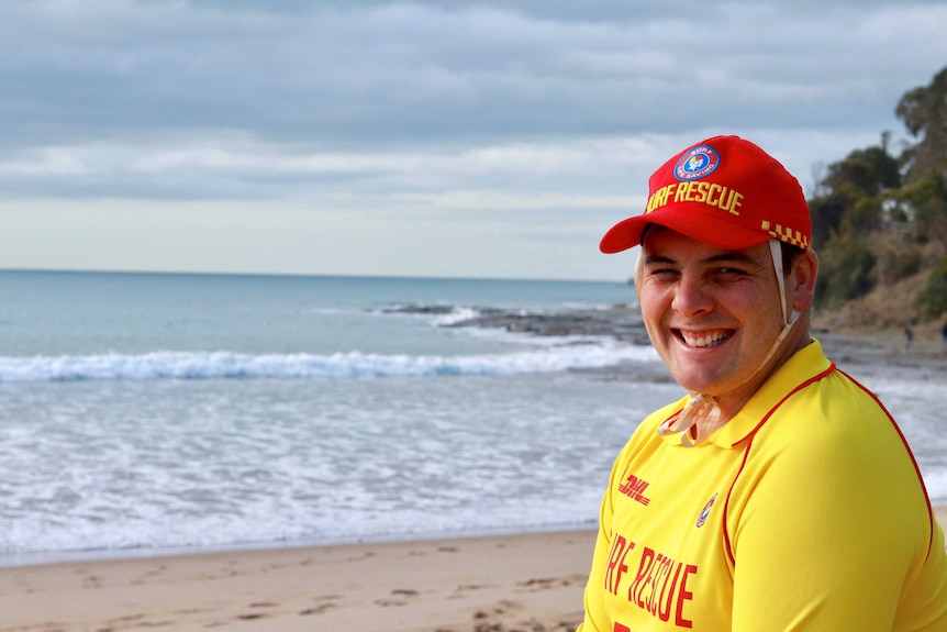 Surf life saver Heath Armstrong wears his uniform on Lorne Beach