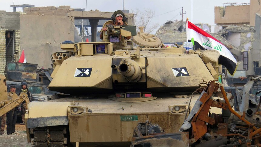 Iraqi counter-terrorism forces drive a tank past rubble south of the Anbar province's capital Ramadi.