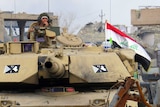 Iraqi counter-terrorism forces drive a tank past rubble south of the Anbar province's capital Ramadi.
