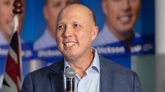 Federal Member for Dickson Peter Dutton smiles while holding a microphone.