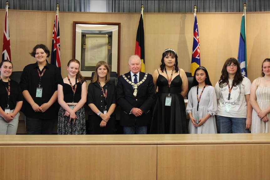 Wollongong City Council Lord Mayor Gordon Bradbery standing between high school students