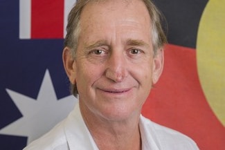 corporate mugshot of official in front of flags.