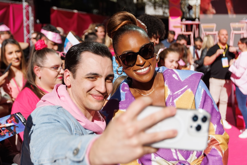 Issa Rae in sunglasses taking a selfie with a fan