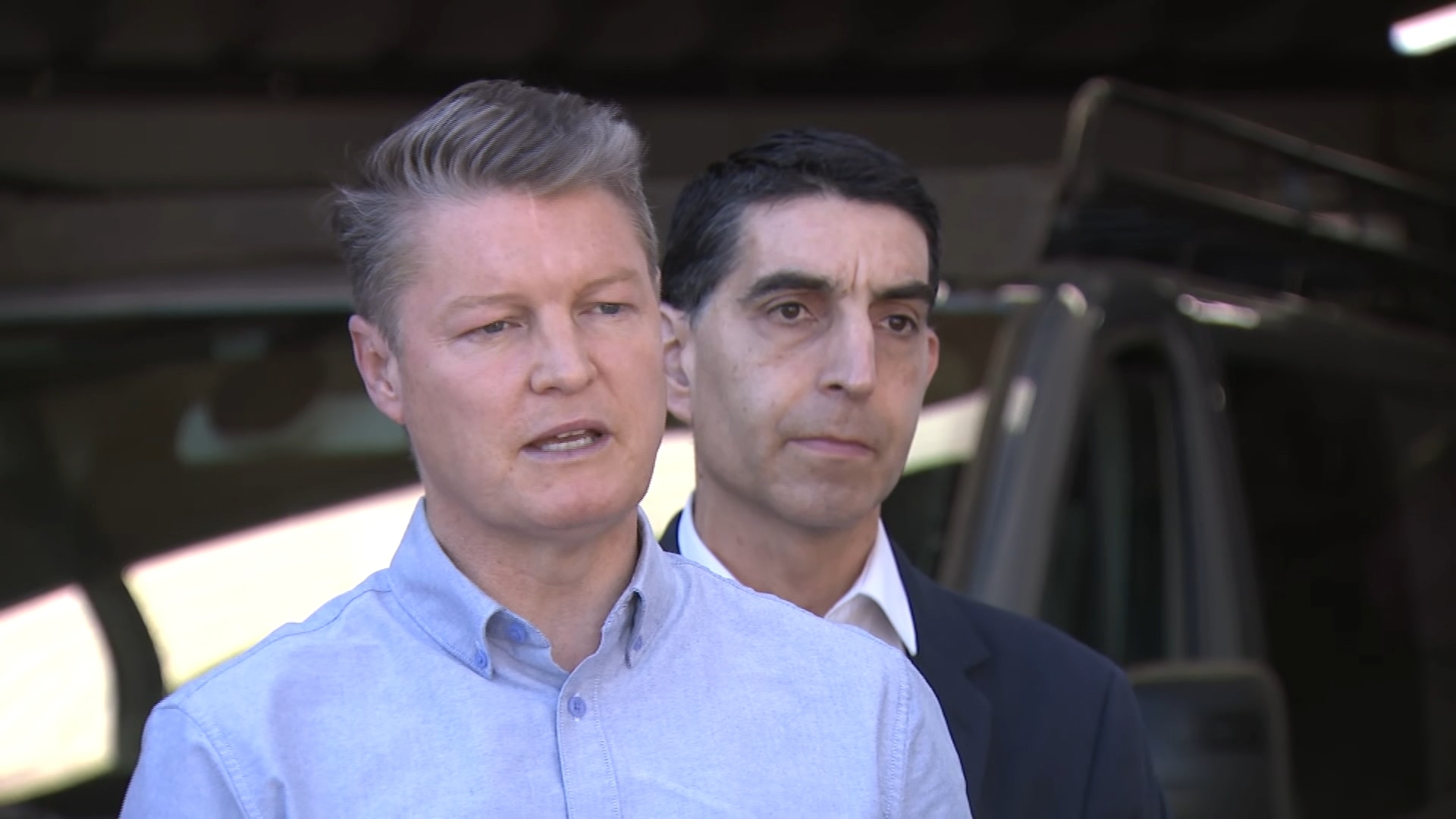 Victorian Premier Ben Carroll at a press conference wearing a blue shirt.