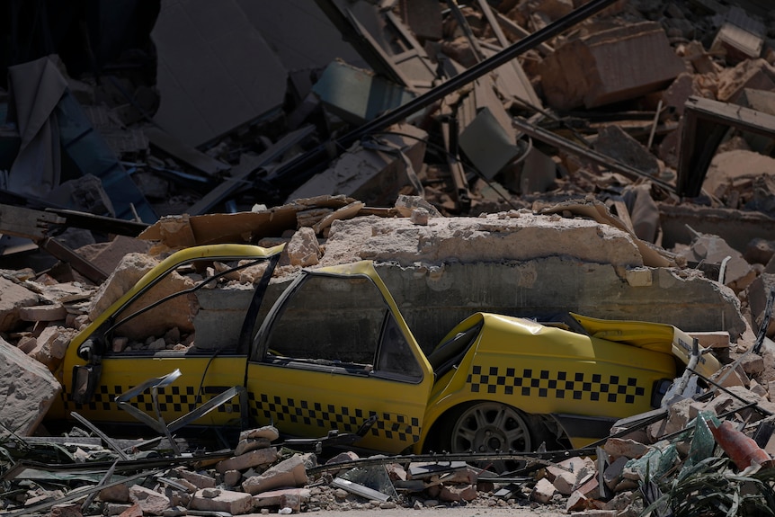 A taxi is buried in rubble at the site of the five-star Hotel Saratoga after a deadly explosion.