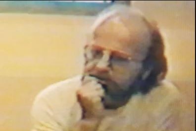 Man wearing glasses sitting in police interview room