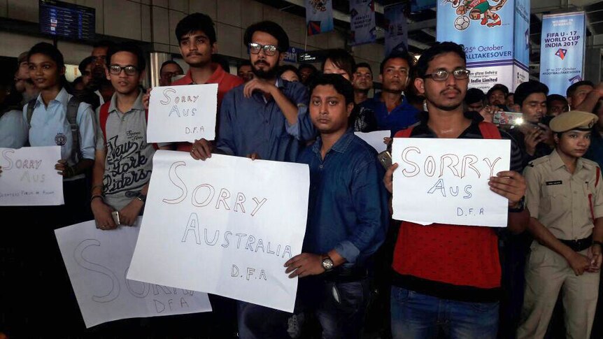 Indian fans hold up signs apologising for rock throwing incident