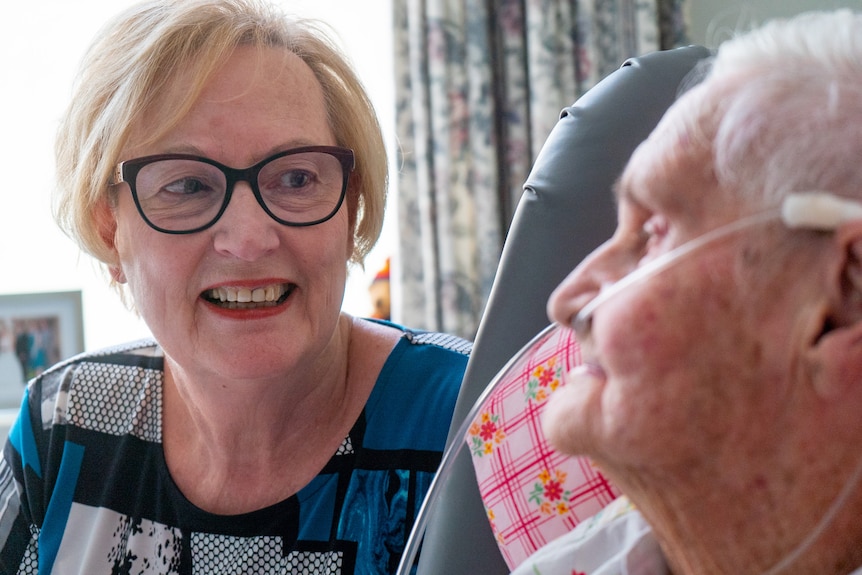 A woman looks at an elderly woman with an oxygen canula