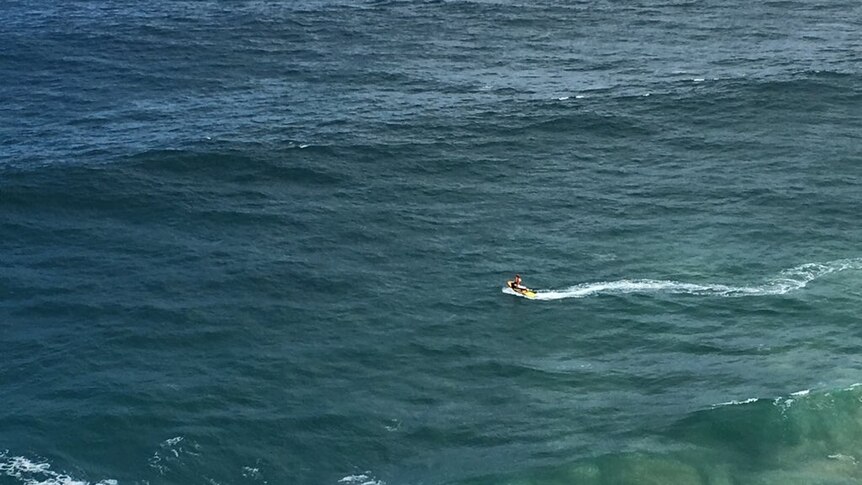 Surf Life Saving Queensland and emergency services search for a man missing in rough sea