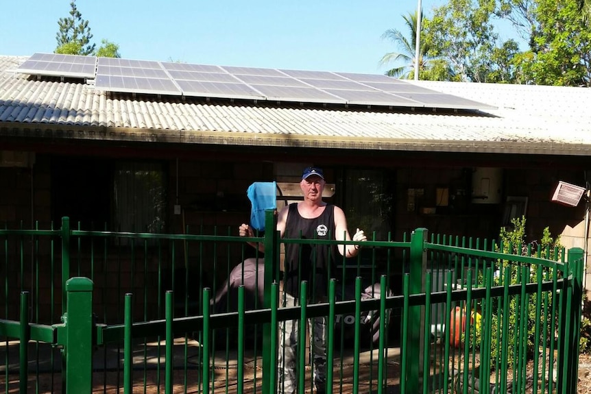 Bryan King points to his solar panels at his home in Palmerston