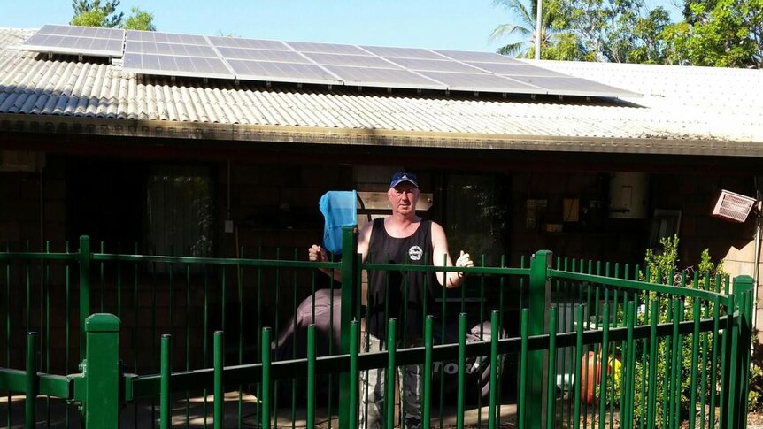 Bryan King points to his solar panels at his home in Palmerston