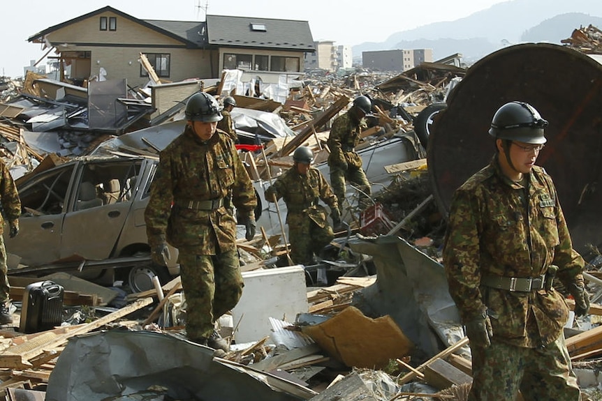 Soldiers from Japan's Self Defence Force search for victims among the rubble (Reuters)