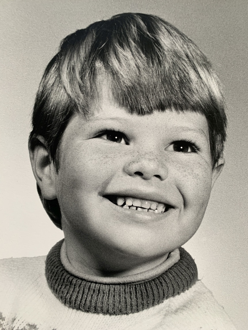 An old image of a young toddler smiling. 