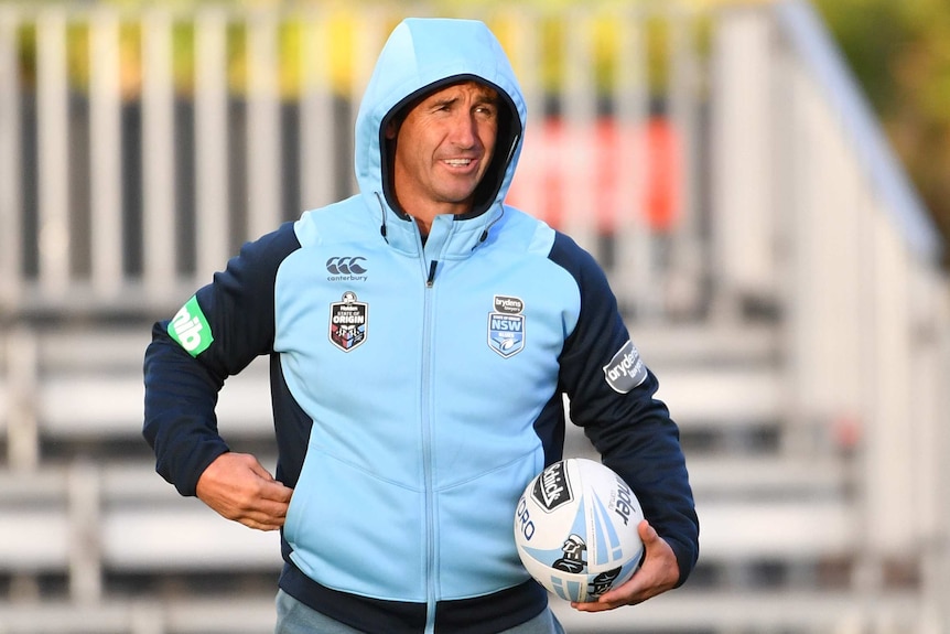 Andrew Johns in a Blues tracksuit holds a rugby ball at NSW Origin training