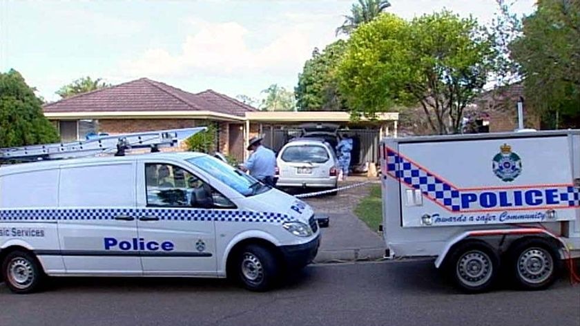 Police vehicles sit outside the house at Sunnybank Hills where the bodies of the toddlers were found