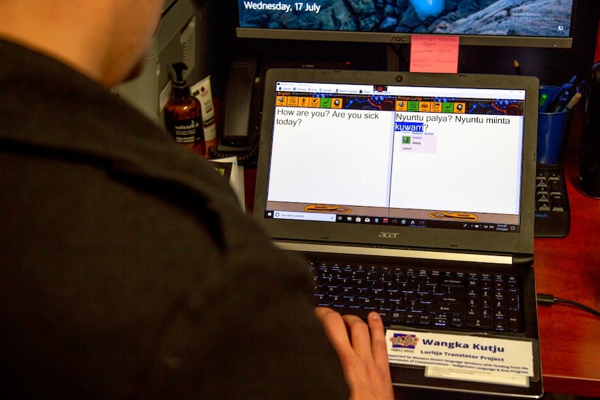 A computer shows a translation app from Pintupi Luritja to English