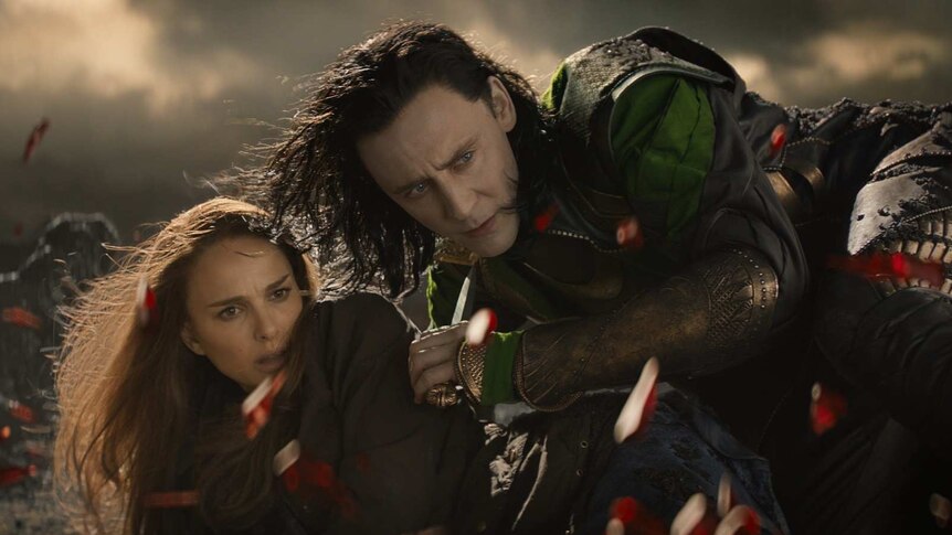Loki protects Jane Foster as the red Aether explodes in front of them.